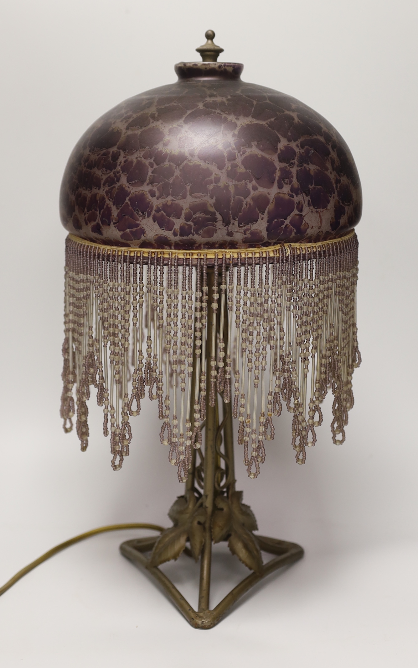 An Art Nouveau style metal lamp and glass shade with beaded fringe, 44cm high